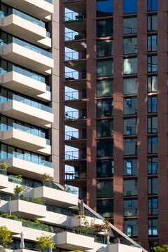 Tall residential buildings featuring numerous balconies with urban greenery and modern architecture, emphasizing vertical living spaces and city life in a bustling metropolitan area in Rotterdam
