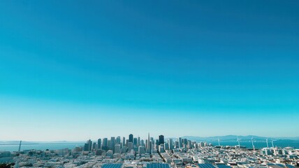 A panoramic view of a city skyline under a clear blue sky, showcasing modern architecture and vast urban landscapes.
