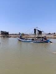 A group of salt transport workers are crossing the river using a small boat