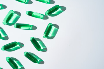 Vitamin E softgel capsules, vitamin D3, fish oil, omega 3, Green oil pills on a white background