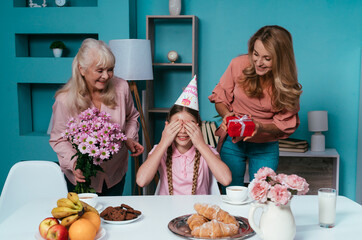 Cincematic image of a senior woman and her daughter and grandaughter celebrating birthday