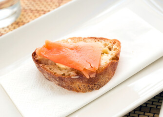 Delicious canapes of salted, smoked salmon fillet on slice of fresh ciabatta bread