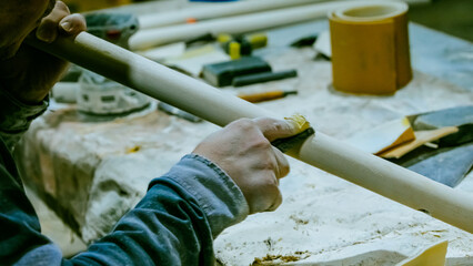 carpenter using nail gun or brad nailer tool on wood box in a workshop ,furniture restoration...