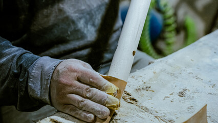 carpenter using nail gun or brad nailer tool on wood box in a workshop ,furniture restoration woodworking concept. selective focus