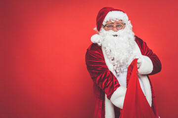 Funny crazy santa claus with tattoo having fun on a red colored background