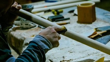 carpenter using nail gun or brad nailer tool on wood box in a workshop ,furniture restoration...