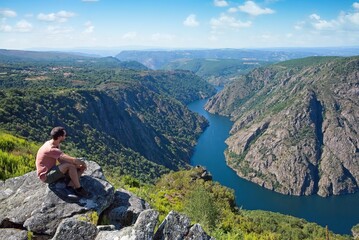 person on the top of the mountain looking at the river canyon