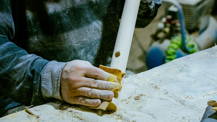 carpenter using nail gun or brad nailer tool on wood box in a workshop ,furniture restoration...