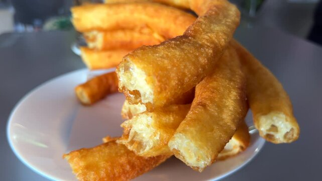Traditional Spanish churros porras in a restaurant in Marbella Malaga Spain, delicious deep fried dough dessert, 4K shot