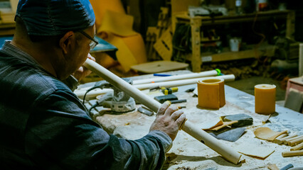 carpenter using nail gun or brad nailer tool on wood box in a workshop ,furniture restoration...