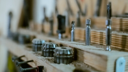 Various tools: file, screwdriver, hammer, pliers, garden tools are displayed on wooden shelf inside rustic garage or manufactory, workshop studio in a rustic garden house. Hobby, leasure activity