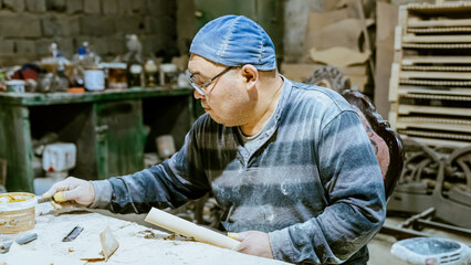 carpenter using nail gun or brad nailer tool on wood box in a workshop ,furniture restoration woodworking concept. selective focus