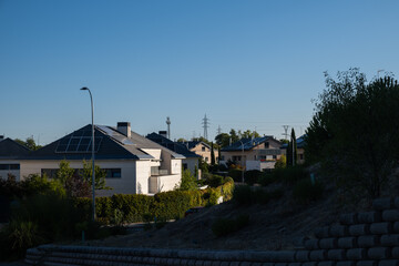 The morning sun illuminates a modern development of individual chalets. They have photovoltaic...