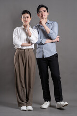 Image of Asian business couple posing on gray background