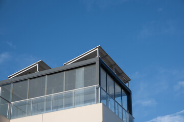 Detail of the roof of a chalet with an installation of photovoltaic solar panels on a light structure. The day is sunny and clear. Concept of sustainable, clean, green and renewable energy.
