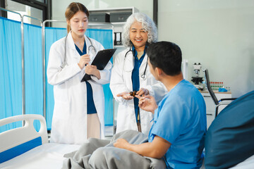 Obraz premium medicine, healthcare and people concept - doctor talking to male patient at bed in hospital.