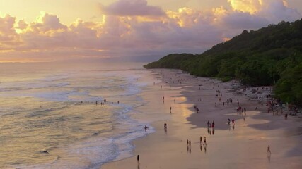 Experience the breathtaking aerial view of Playa Santa Teresa located in Puntarenas, Costa Rica. This beautiful scene captures the vibrant sunset colors painting the sky above the beach and ocean
