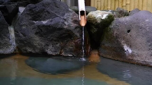 温泉宿の源泉掛け流しの露天風呂でのんびりリラックスしているイメージ（スローモーション）
