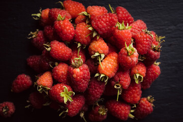 Ripe and juicy raspberry on the dark rustic background. Selective focus. Shallow depth of field....