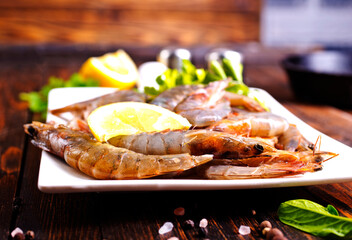 Uncooked Raw peeled tiger white shrimp prawn. Dark background.