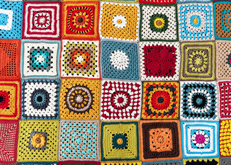 Rainbow colored granny squares background. Handmade crocheting, needlework and handicraft concept. Lay flat. 