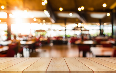 Empty wooden table top with lights bokeh on blur restaurant background.	