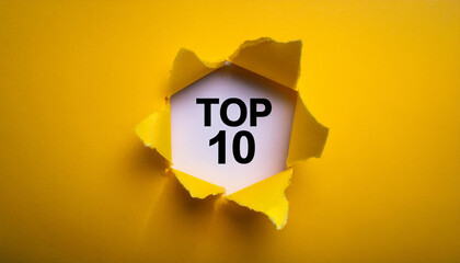 Torn paper revealing text Top 10, bright background. Business concept.