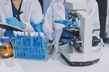 Scientist using microscope in laboratory. Close-up of a researcher's hands adjusting a modern...