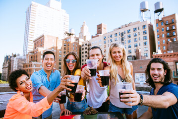 Group of friends spending time together on a rooftop in New york city, lifestyle concept with happy people