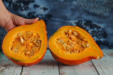 sliced hokkaido pumpkin pieces on rustic wooden surface
