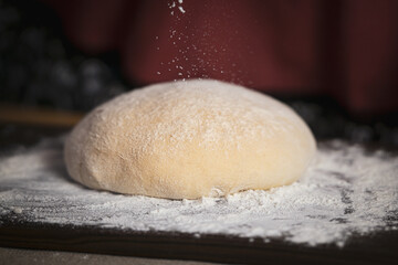 Yeast dough on the kitchen board, warm homely atmosphere.