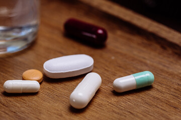 Close-up of capsules and water on wooden surface