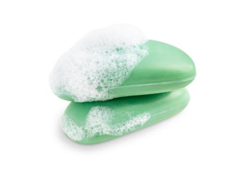 Side view of two wet hygienic handmade antibacterial soap bars of green colour covered with foamy bubbles isolated on white background used for cleaning and as toiletries for bathroom body care
