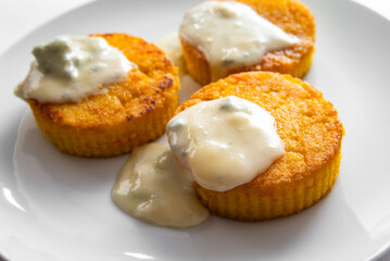 Medaglioni di polenta con gorgonzola fuso, cibo italiano vegetariano 