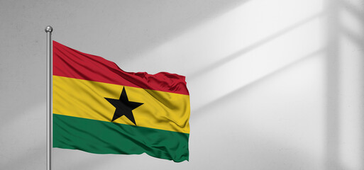 Ghana national flag cloth fabric waving on beautiful window light grey Background.
