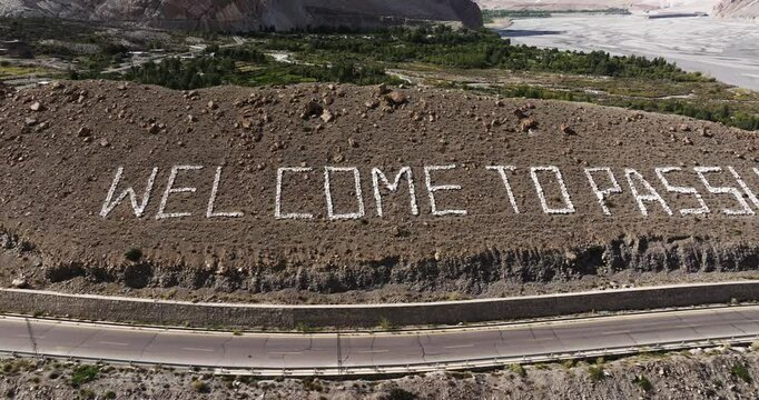 Cinematic Aerial View Above 'Welcome to Passu' Sign. Northern Pakistan Tourist Destination