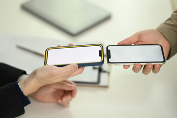 Young men sharing data or contact through their smartphone. Technology, data transfer, or collaboration