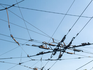 industrial urban background, intertwining cables over the street at the intersection of trolleybus contact wires