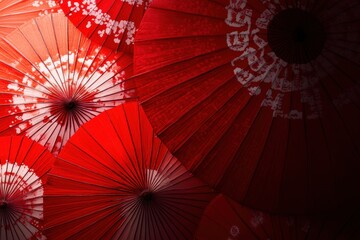 Close-up view of a red umbrella with intricate white patterns and raindrops creating a delicate and artistic design