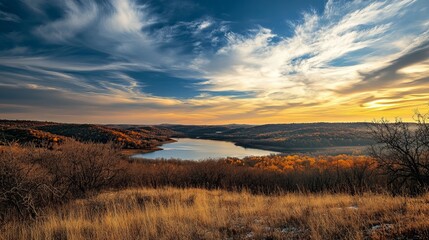 Fototapeta premium Perched at the top of a hill, a breathtaking view unfolds over a serene lake nestled below, offering a 