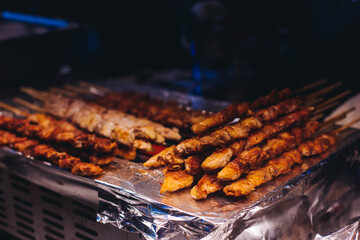 Korean barbecue, Ddakkochi, grilled chicken and pork skewers, variety of different traditional street food selection in Seoul, South Korea, night market with local vendor stalls cooking tasty dishes