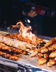 Korean barbecue, Ddakkochi, grilled chicken and pork skewers, variety of different traditional street food selection in Seoul, South Korea, night market with local vendor stalls cooking tasty dishes