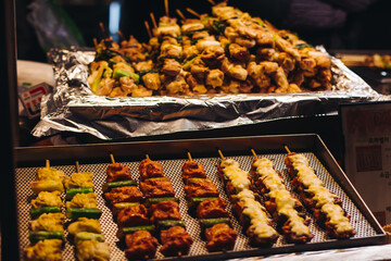 Korean barbecue, Ddakkochi, grilled chicken and pork skewers, variety of different traditional street food selection in Seoul, South Korea, night market with local vendor stalls cooking tasty dishes