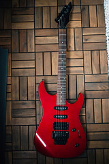 red electric guitar on wooden floor background