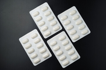 Tablet pills blister Medicine capsules on a black background