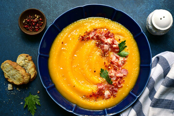 Autumn pumpkin soup with smoked bacon. Top view with copy space.