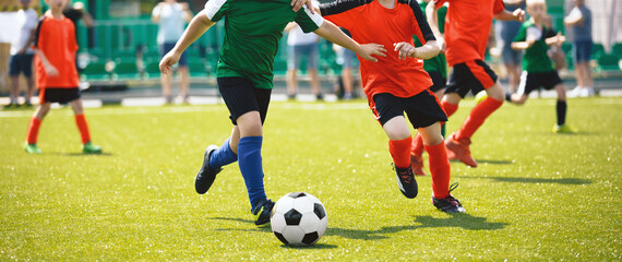 Young boys playing soccer game. Training and football match between youth soccer teams. Junior competition between players running