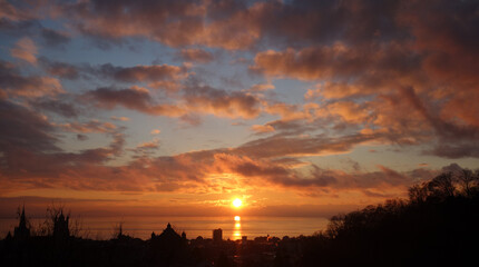 Sunset from Lausanne, Switzerland, with orange clouds and a blue sky