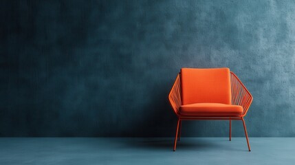 A stylish modern orange chair with geometric design placed against a textured blue wall, showcasing contemporary furniture design in a minimalist room setting.