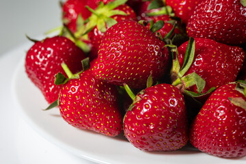 Fresh ripe delicious strawberries in a white plate on a white background